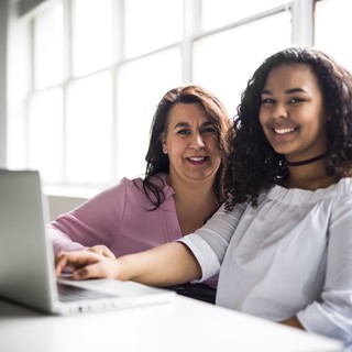 Volunteer and teenager with a laptop
